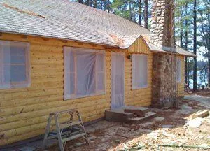 Log cabin exterior being chinked and painted